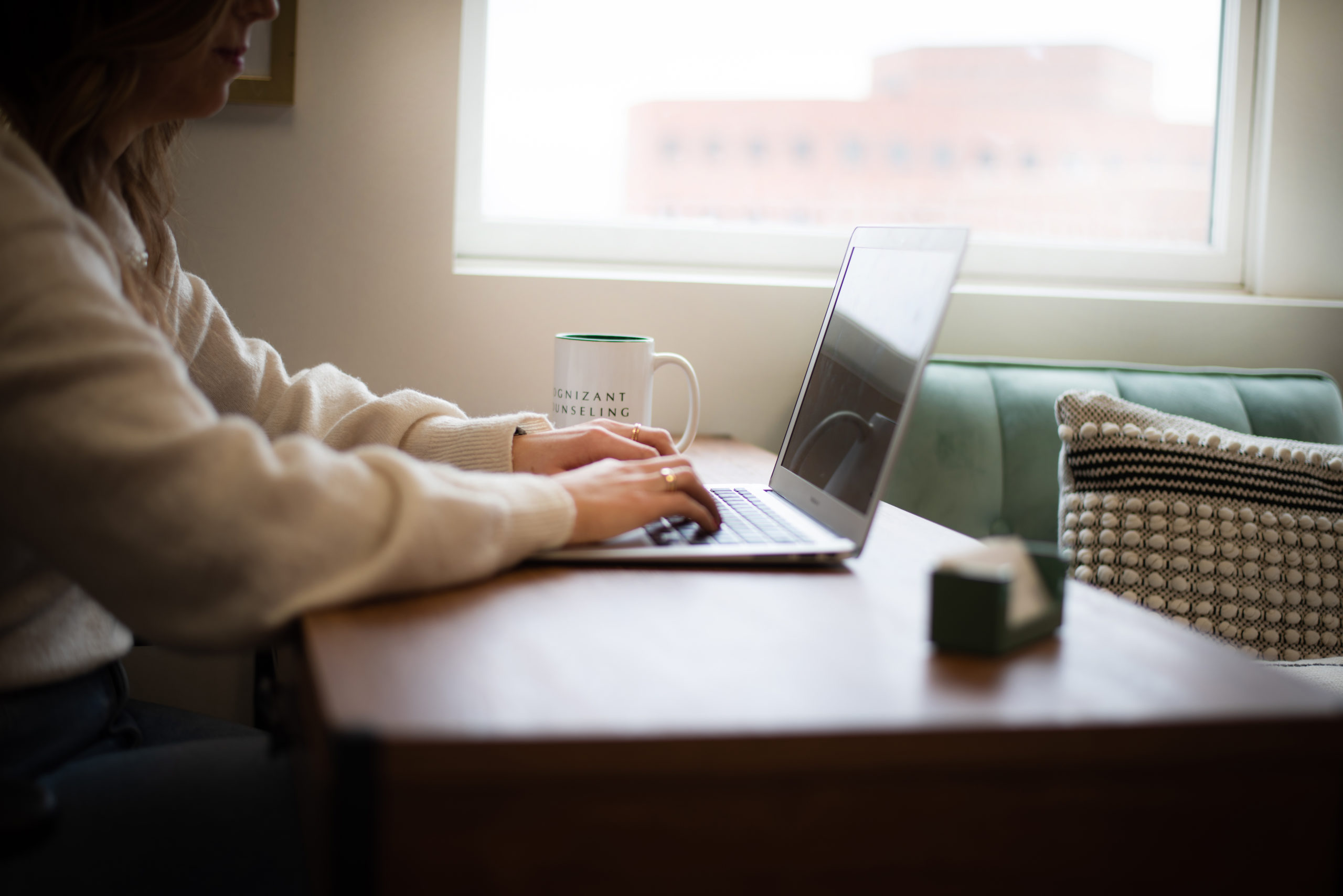 woman typing on a laptop at a desk