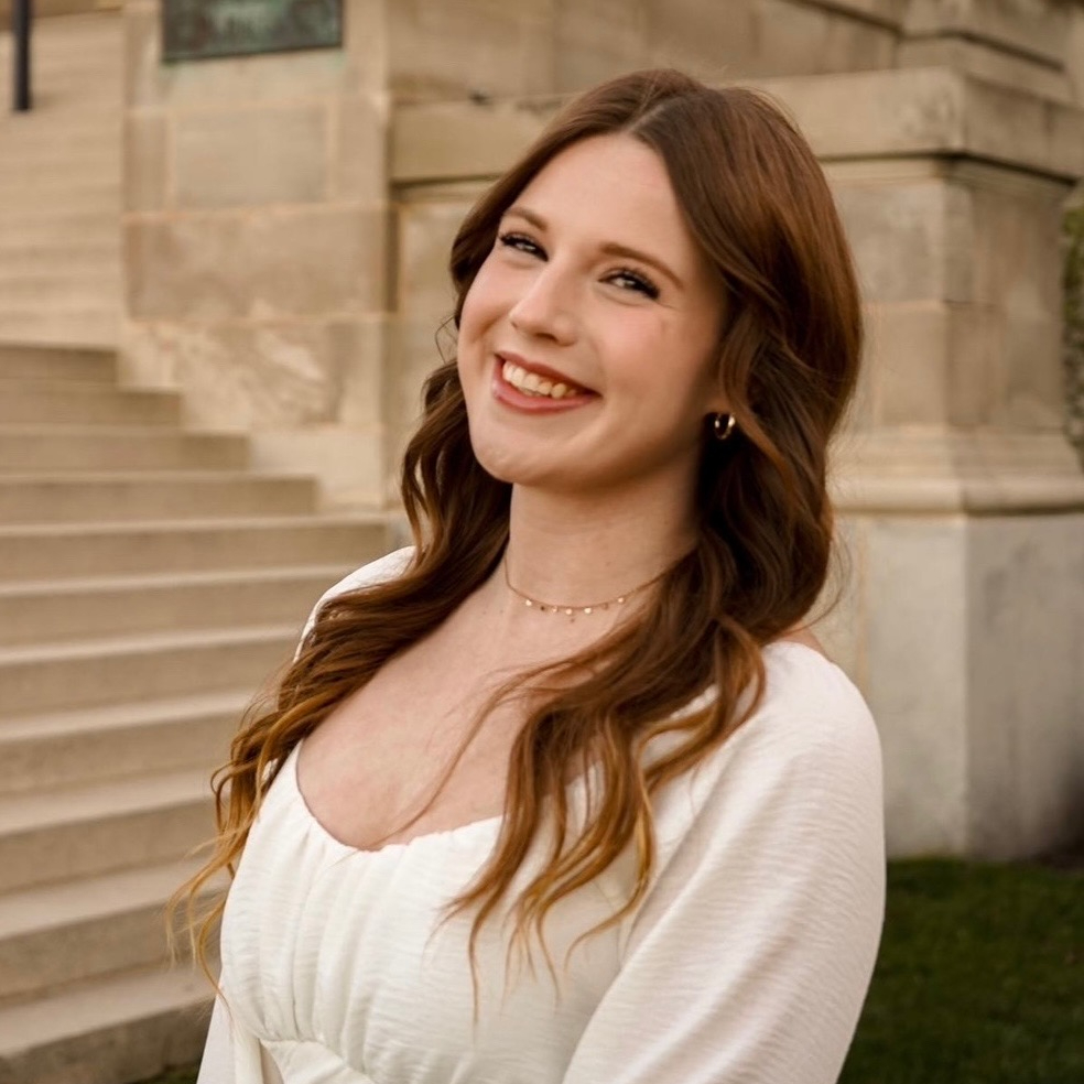 Woman smiling in front of steps.